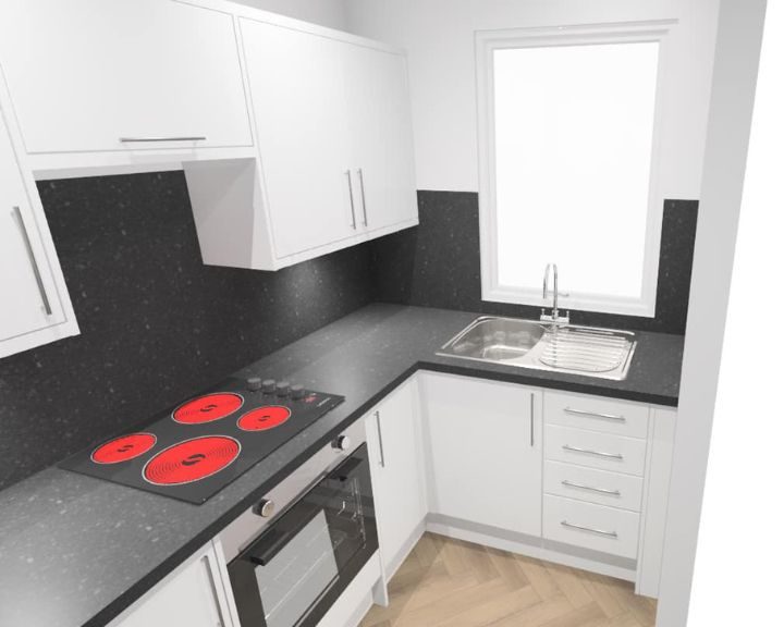A Howdens kitchen design featuring white kitchen cabinets and cupboards, grey countertops, integrated hob and cooker with black tiled walls.